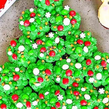 A festive display of Christmas desserts, featuring a delightful christmas tree made entirely of delectable cupcakes.