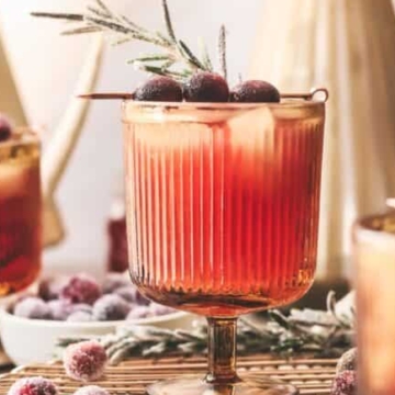 A festive holiday cocktail adorned with cranberries and berries set elegantly on a table.