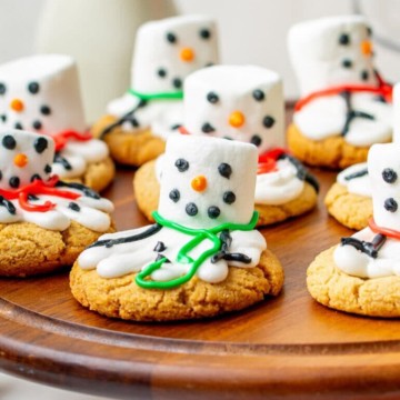 snowman cookies on a cake stand.