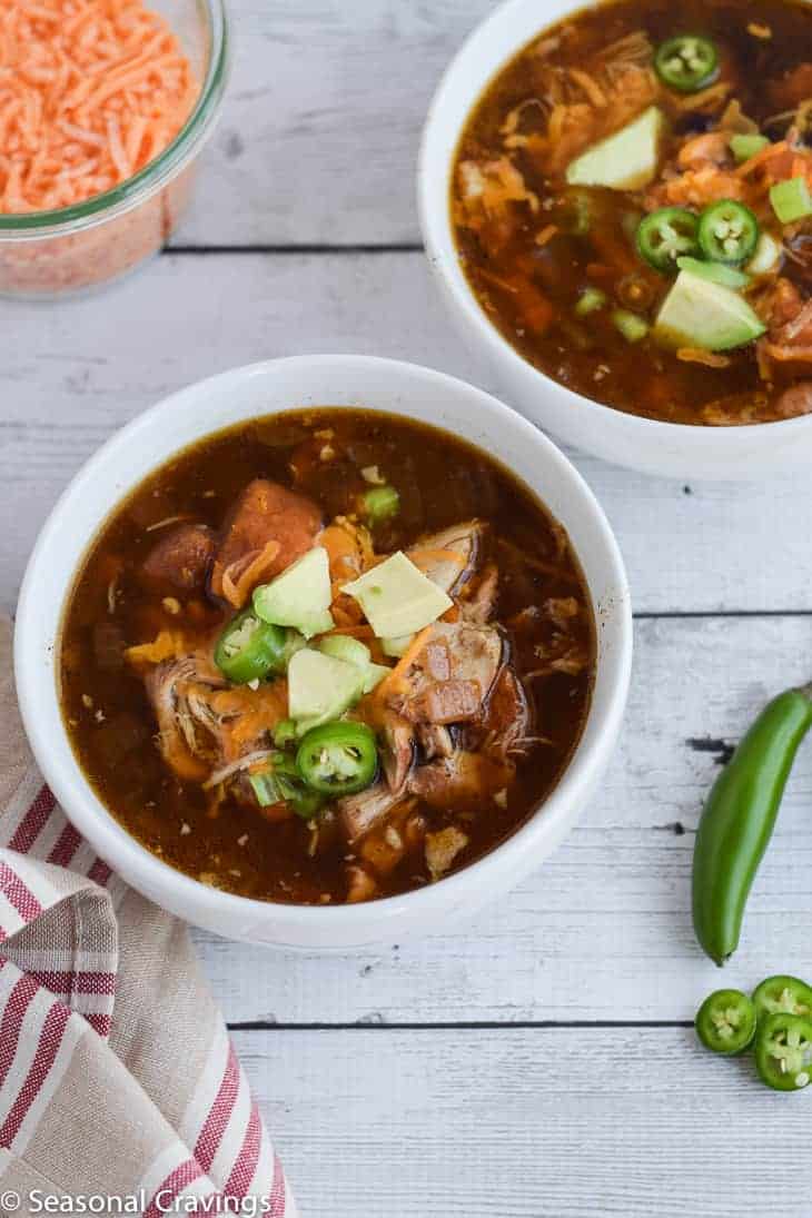 Slow Cooker Mexican Chicken Tortilla Soup with avocado, jalapenos and cheese in two small white serving bowls. #crockpot 
