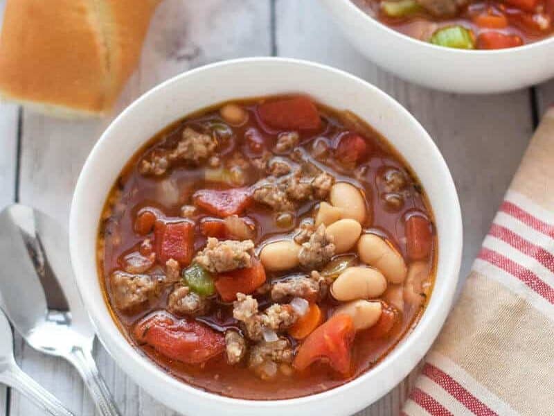 Two bowls of sausage and bean soup. 