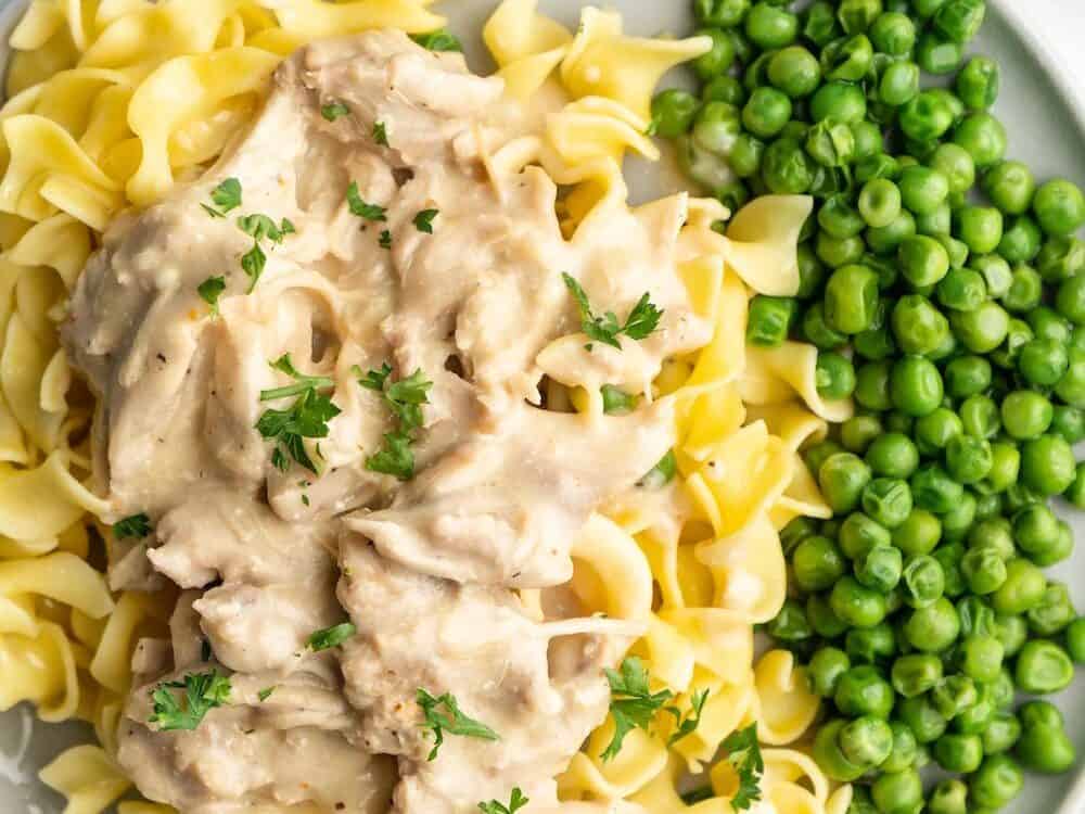 Crockpot chicken and gravy with pasta and peas. 