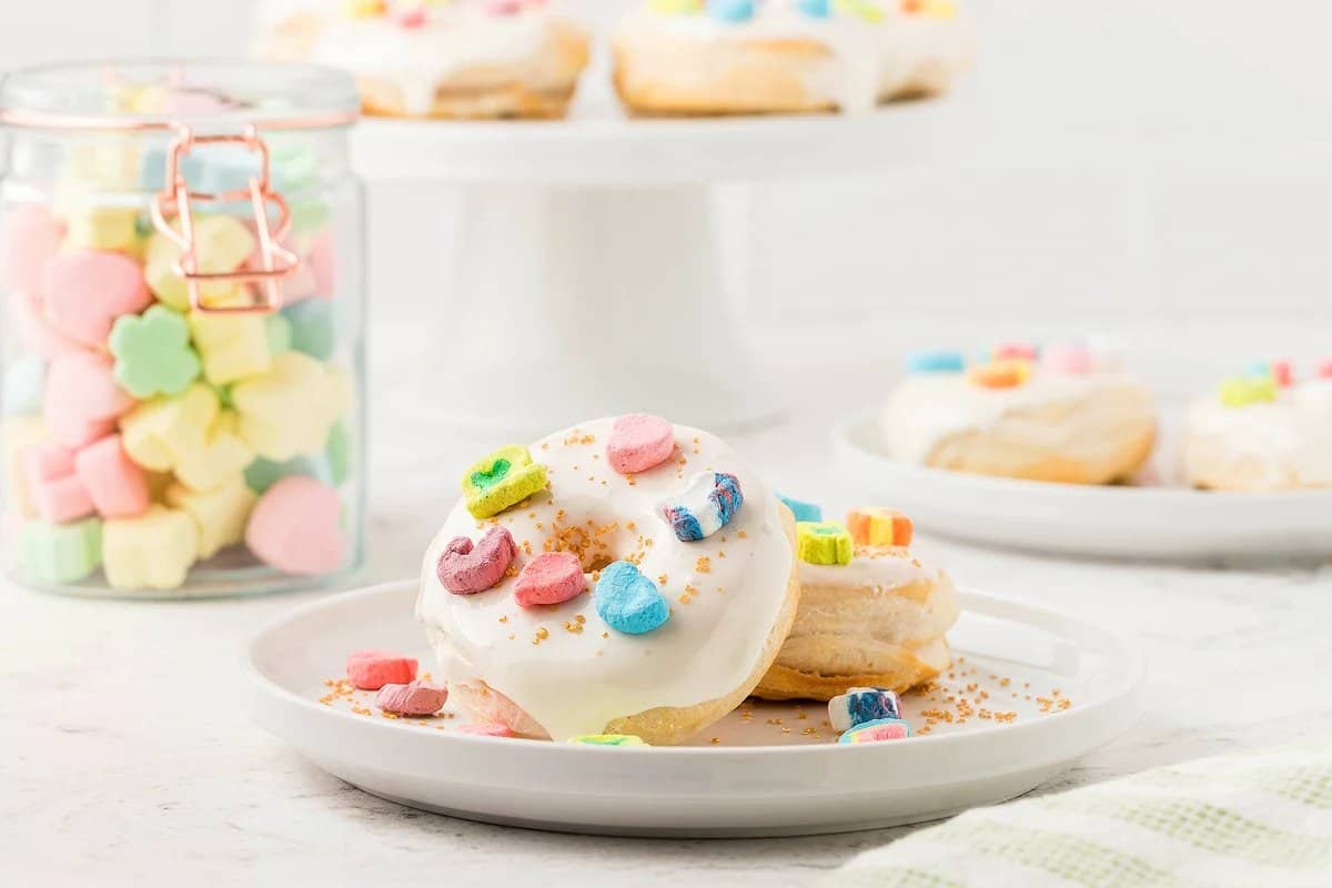 Two pieces of Air Fryer Lucky Charms Marshmallow Donuts on a plate.
