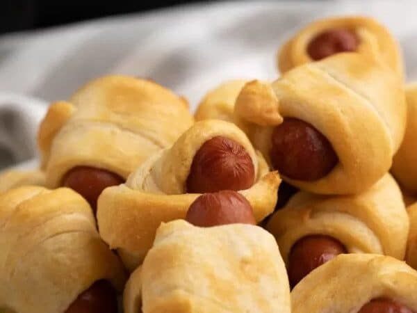 Pigs in a blanket on a white plate.