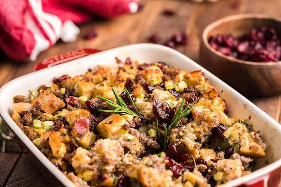 Sausage stuffing with fresh herbs in a casserole dish.