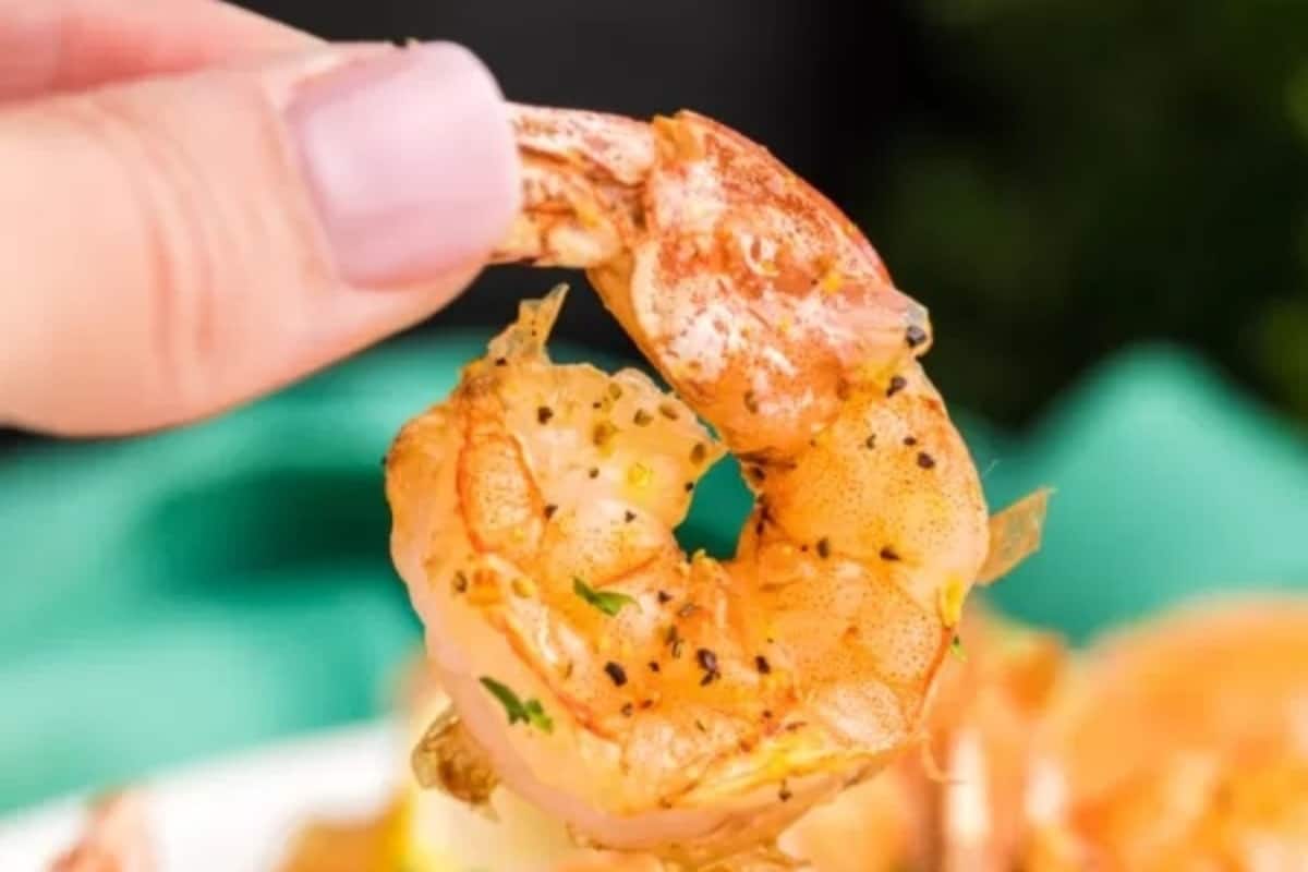 A person holding a shrimp.