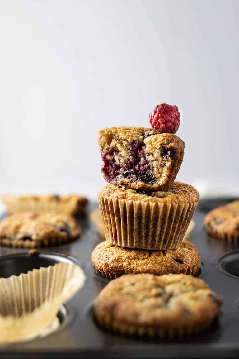 Almond Flour Raspberry Muffins stacked on top of each other. 