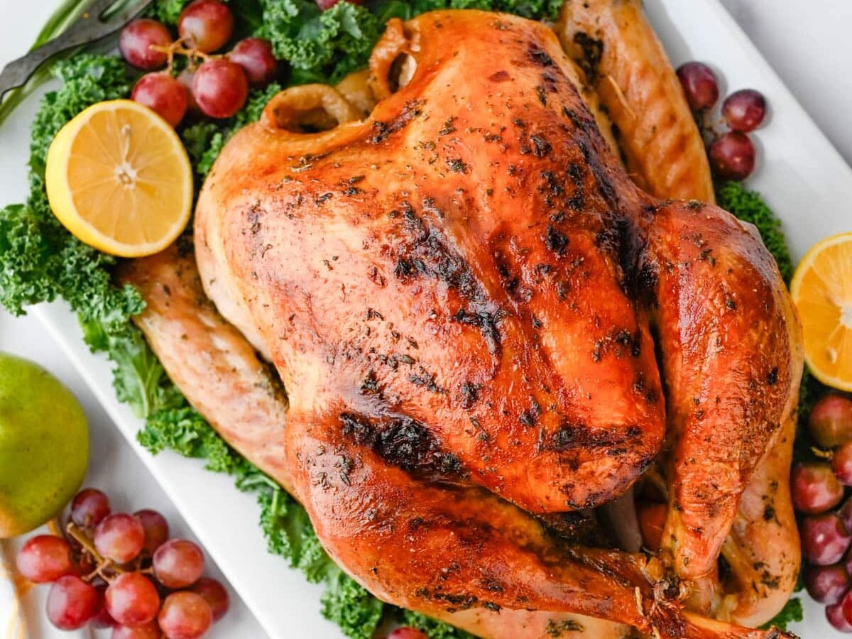 Bourbon Maple Brined Roast Turkey served with grapes and lemon.