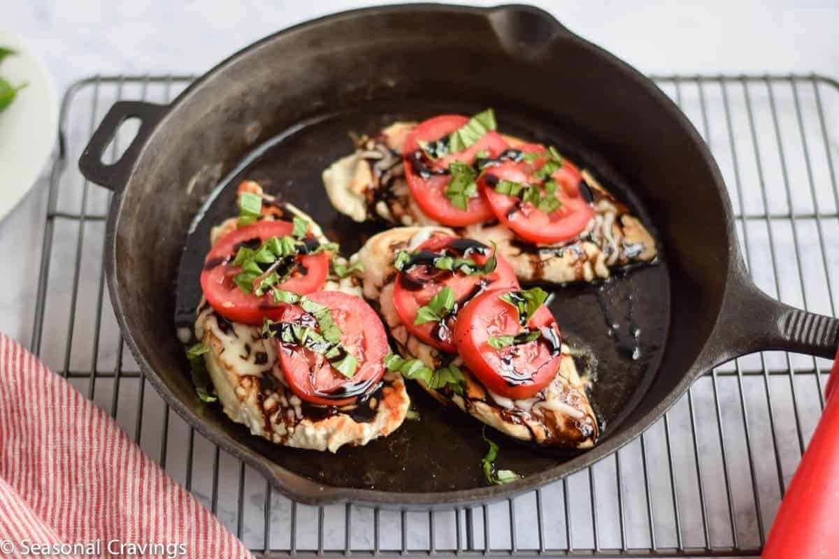 Chicken breasts with tomato and glaze in a pan.