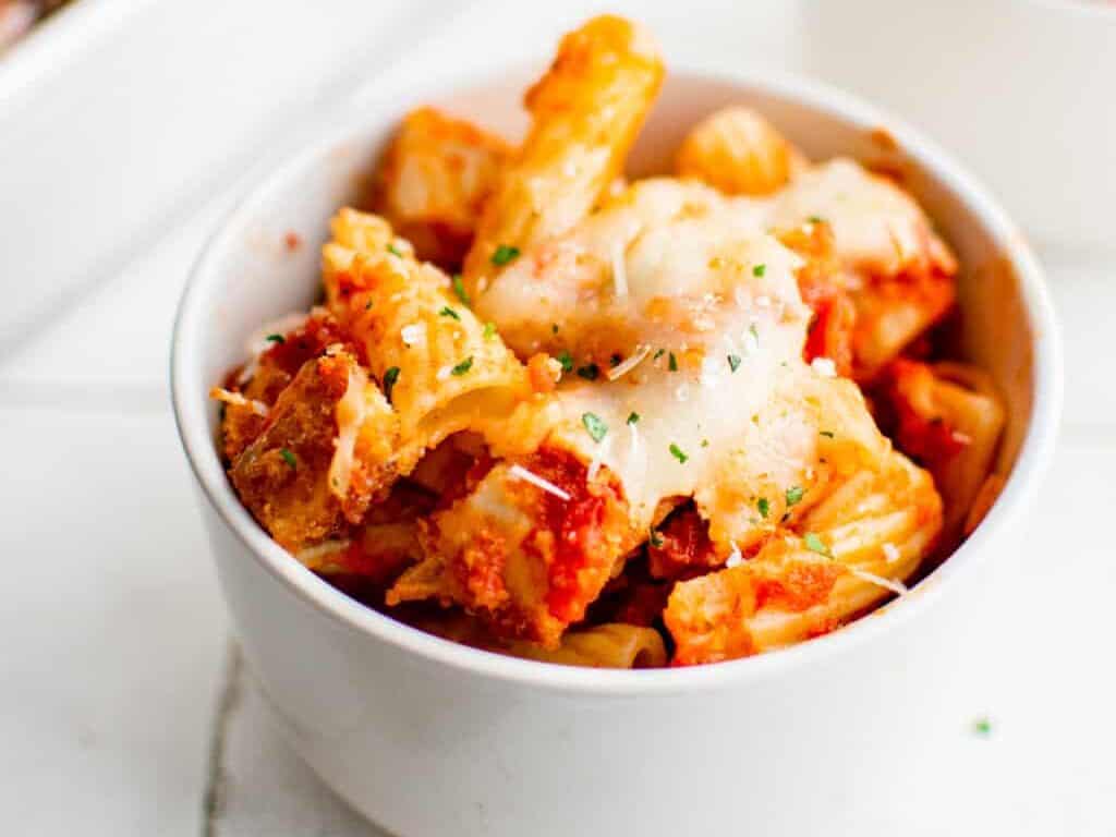A bowl with chicken parm pasta casserole.