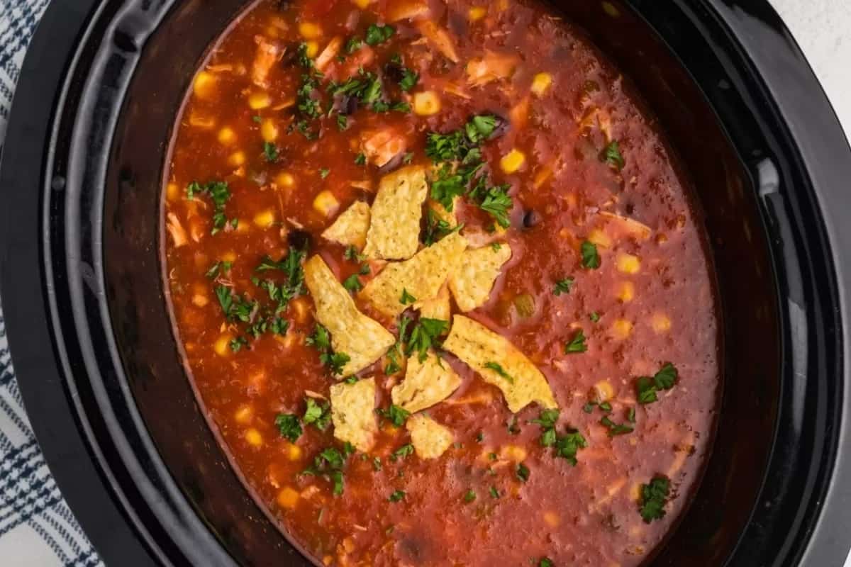 Chicken tortilla soup with tortilla chips and cheese.