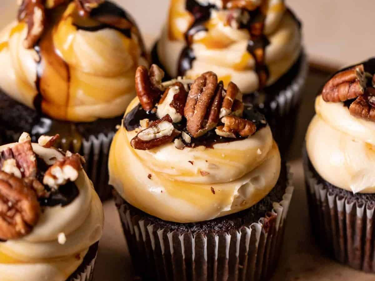 Chocolate turtle cupcakes on parchment paper.