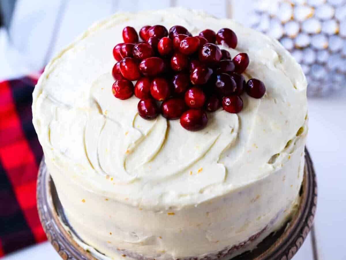 Cranberry orange cake with frosting and cranberry toppings.