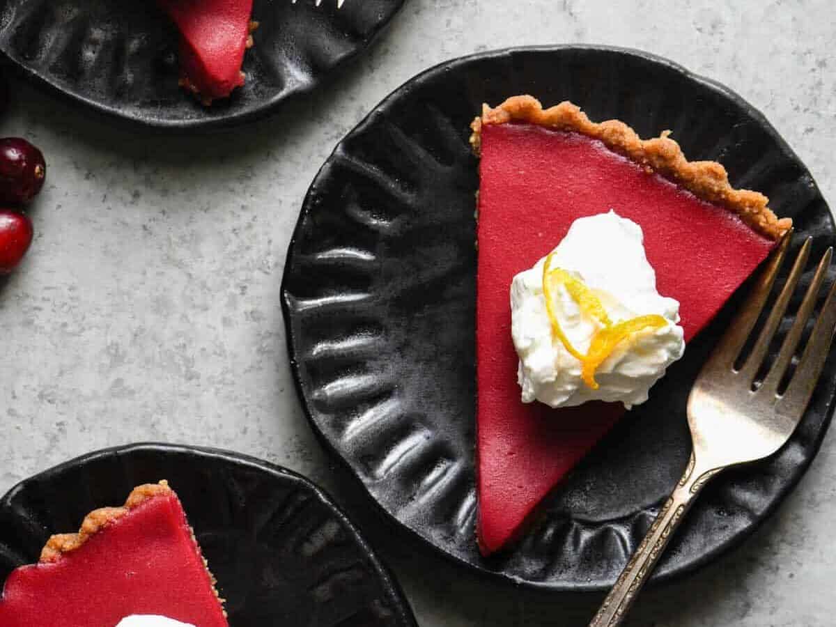 Slices of Cranberry Tart Pie on a round, black plate.