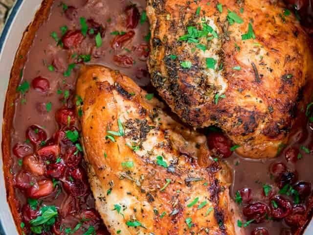 A pan of cranberry sauce with roasted turkey breast.