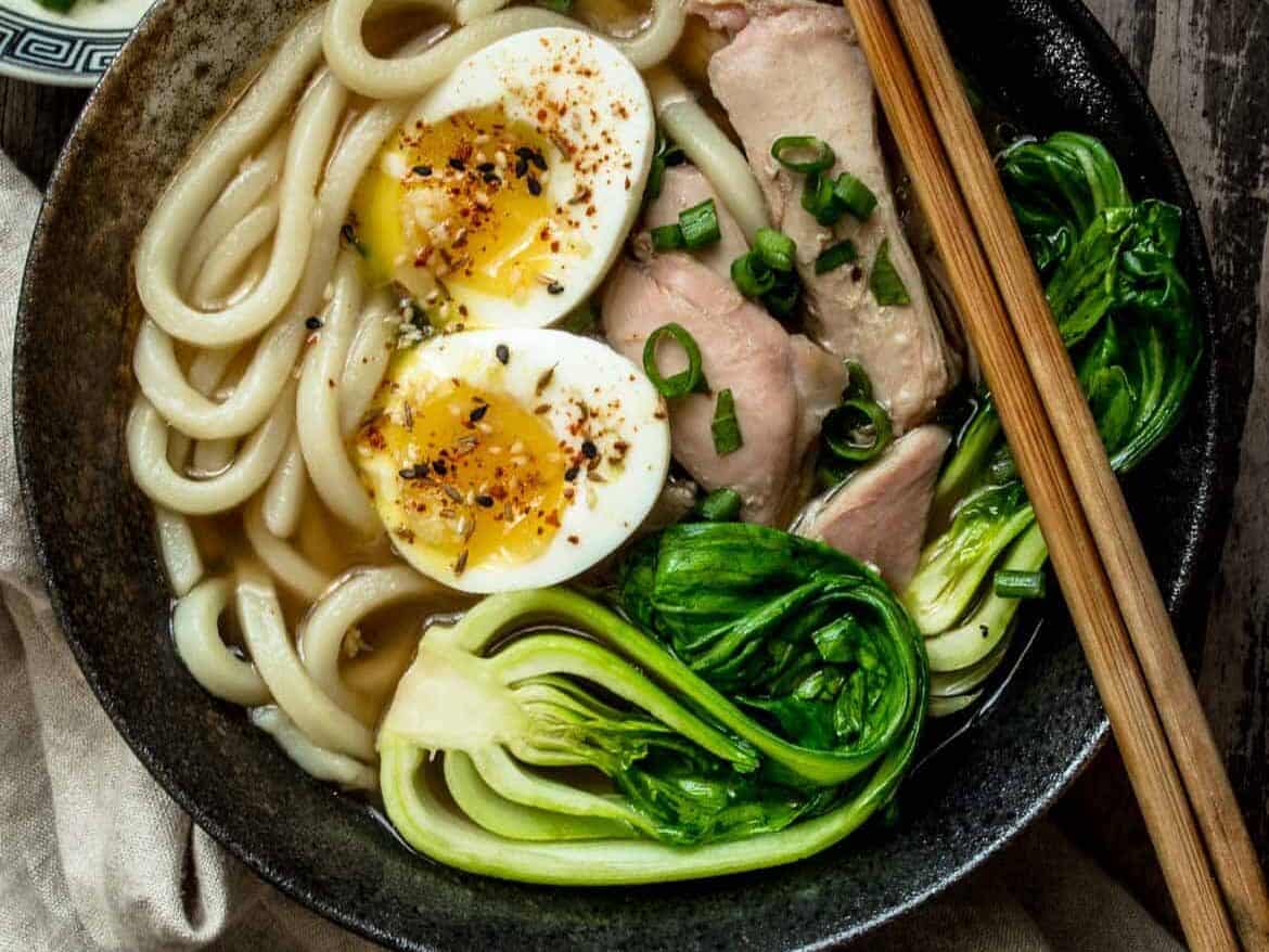 Homemade udon soup in a bowl with chopsticks.