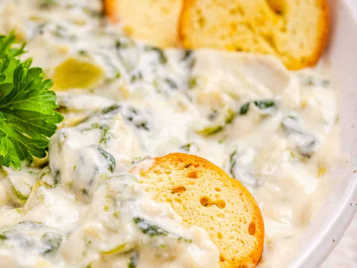 Spinach dip with a piece of bread dipped in.