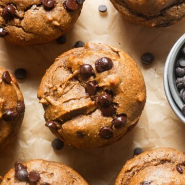 Gluten free chocolate chip muffins with a cup of chocolate chips.