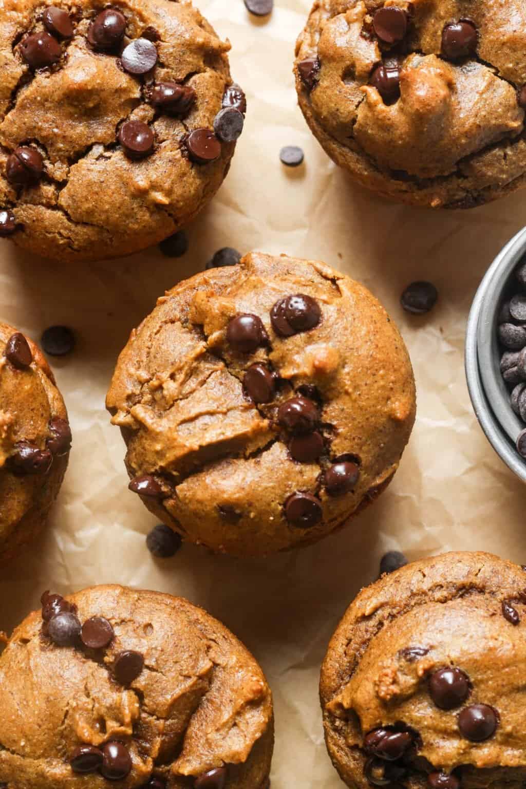 Gluten free chocolate chip muffins with a cup of chocolate chips.