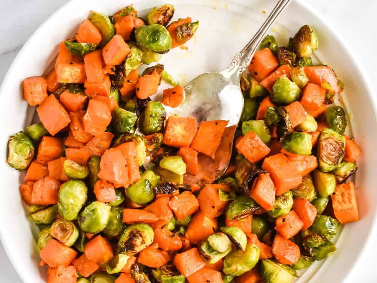 Roasted Brussels Sprouts And Sweet Potatoes  with spoon. 