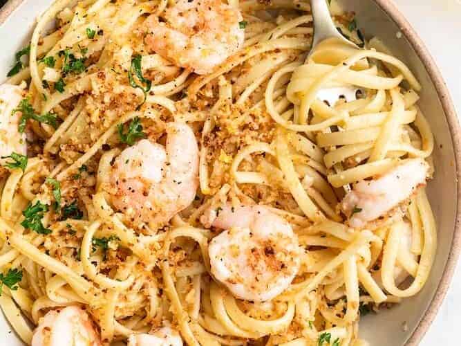 A bowl of pasta with shrimp and parmesan.