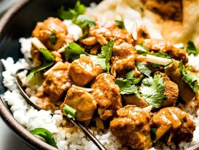 A bowl of Slow Cooker Butter Chicken over rice. 