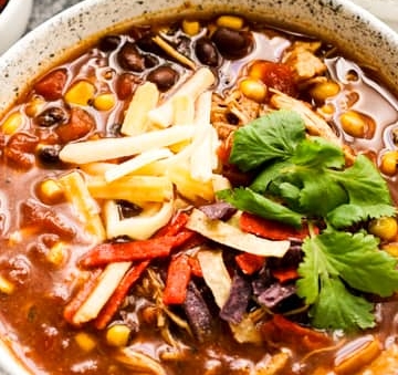 Two bowls of Mexican chili soup, a delicious variation of taco soup, are displayed on a sleek marble table.