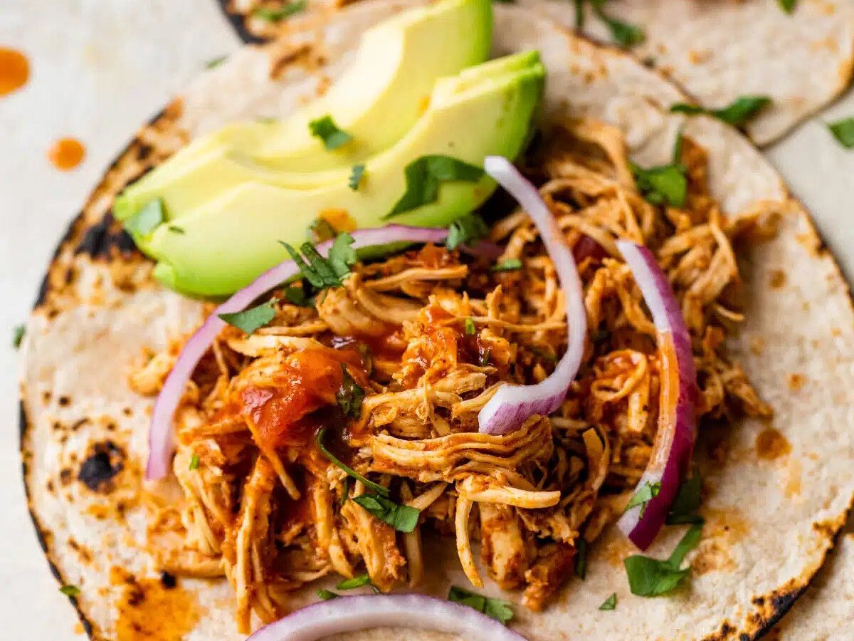 A slow cooker chicken taco on a plate.