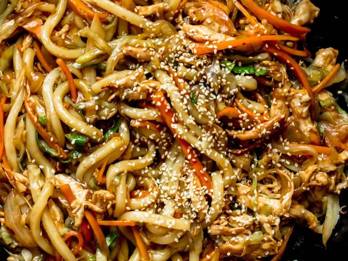 Stir fried udon noodles with chicken and sesame seeds.