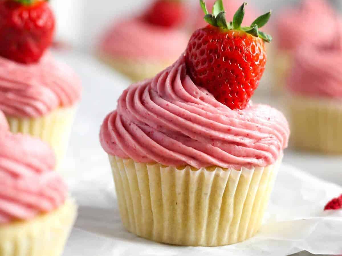 Strawberry Filled Cupcakes with pink frosting and fresh strawberry. 