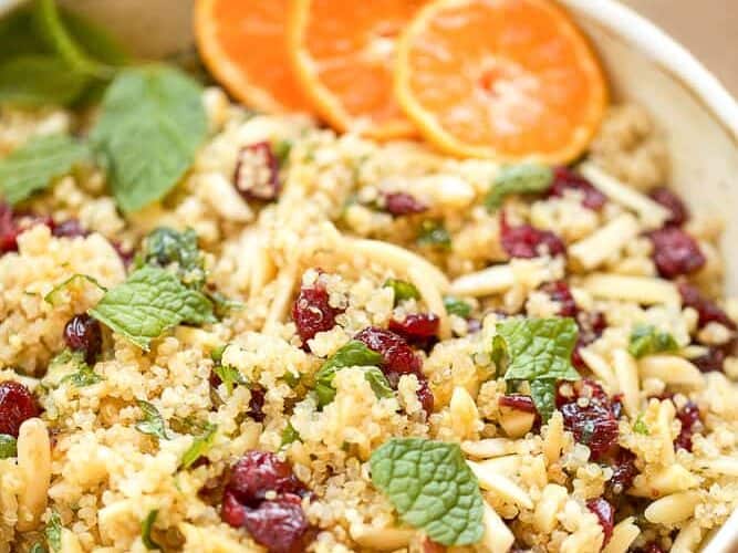 A bowl of Cranberry Almond Quinoa salad with cranberries and oranges.