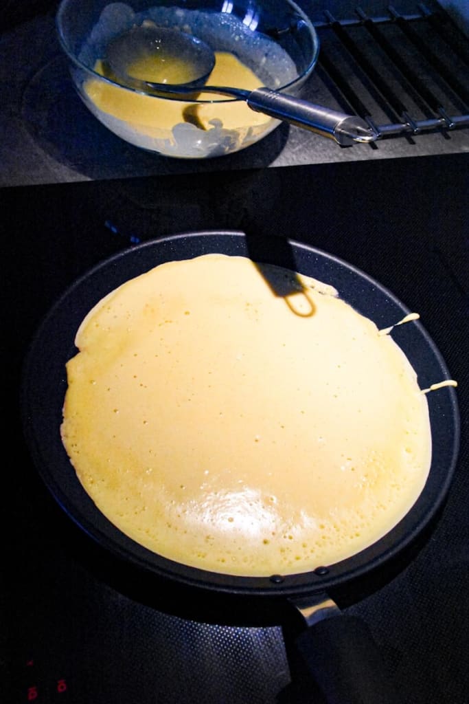 crepe cooking in a skillet.