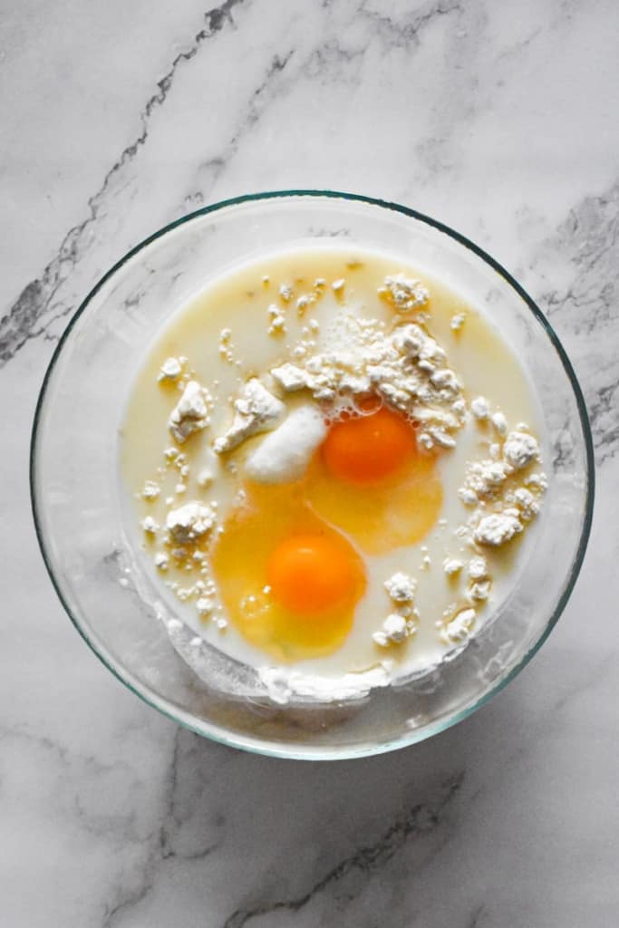 crepe ingredients with eggs in a bowl.
