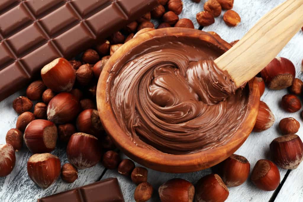 Chocolate and hazelnuts in a wooden bowl.