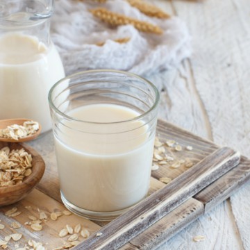 Vegan oat milk, non dairy alternative milk in a glass close up