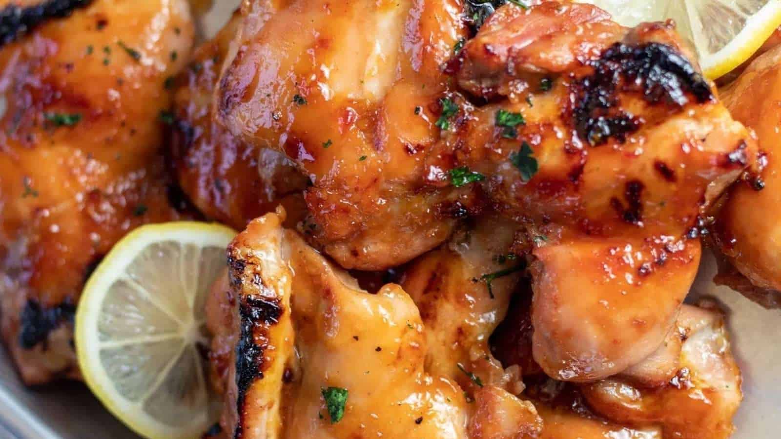 Grilled chicken wings with lemon wedges on a plate.