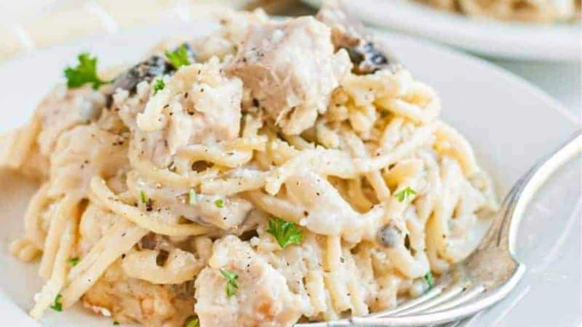 A plate of pasta with chicken and mushrooms.