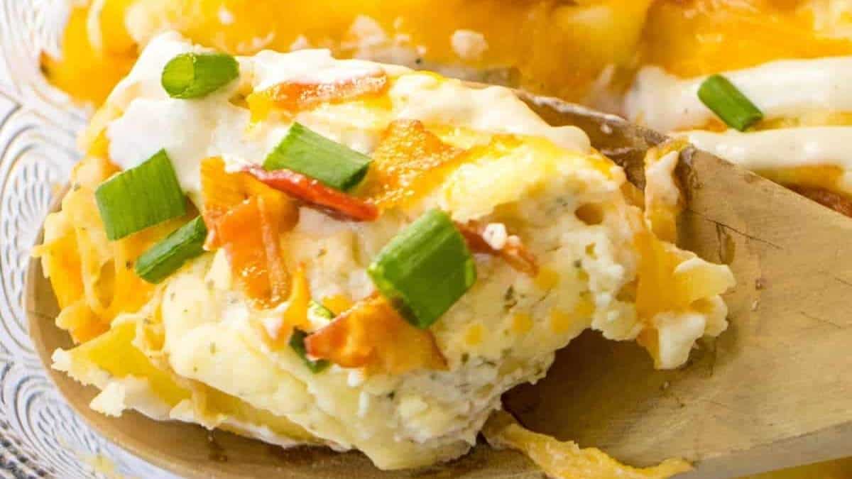 A spoonful of cheesy potato casserole on a plate.