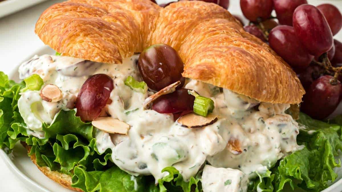 Chicken salad on a croissant with grapes and almonds.