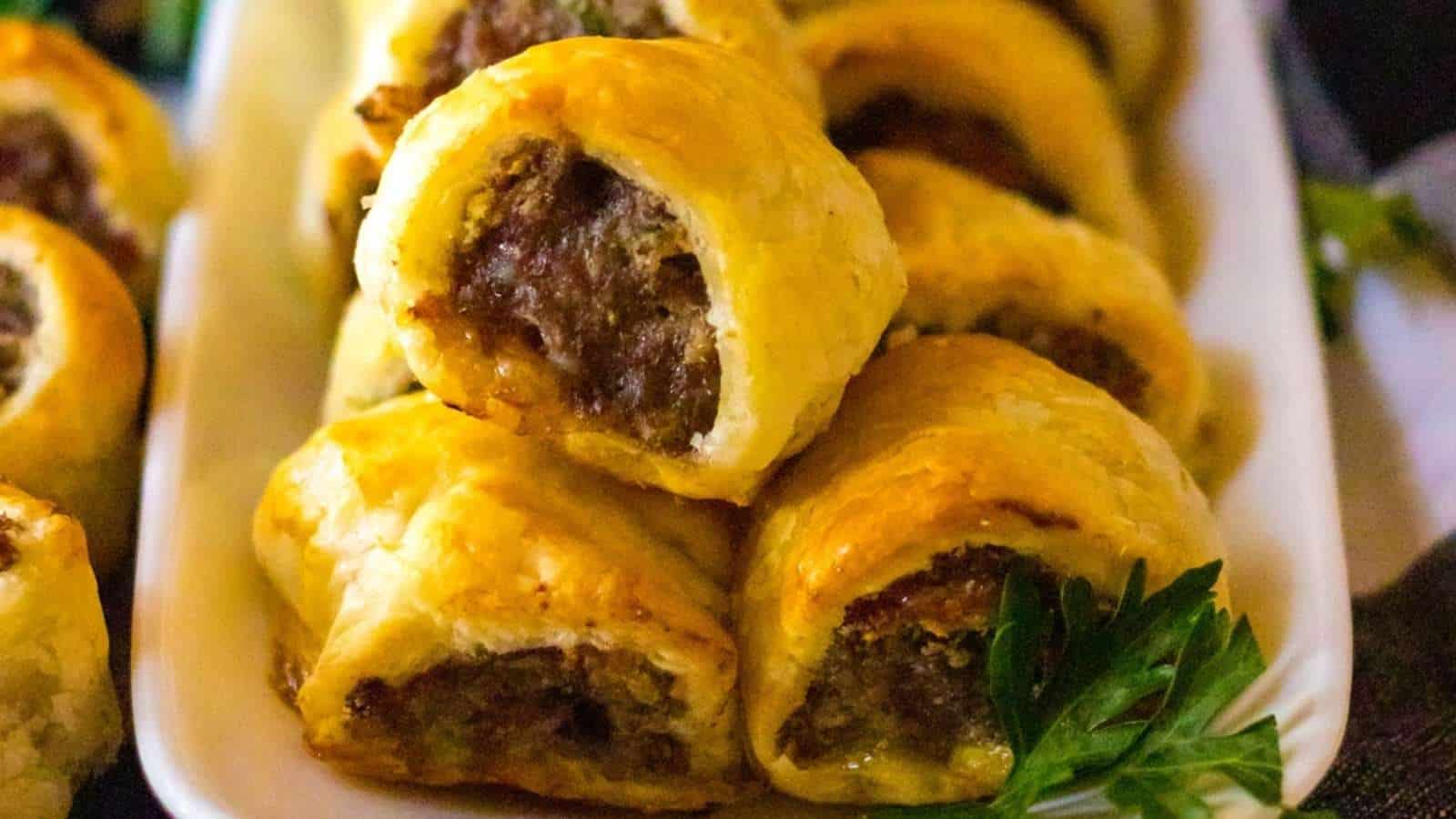 A plate of meat and cheese pastries on a white plate.