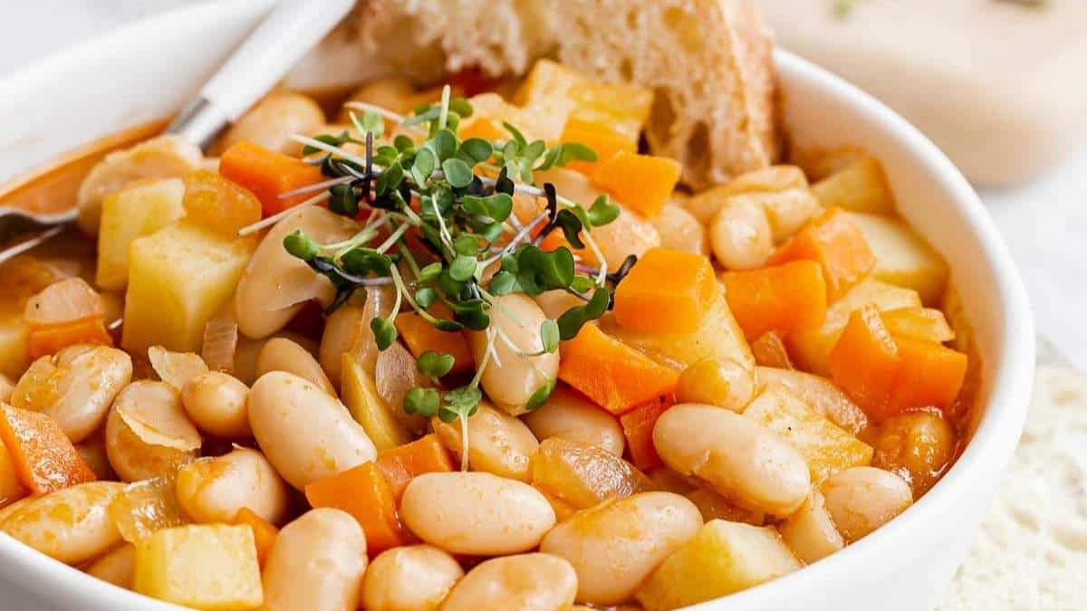 A delicious bowl of white bean soup with carrots and bread, perfect for those seeking new soup recipes.
