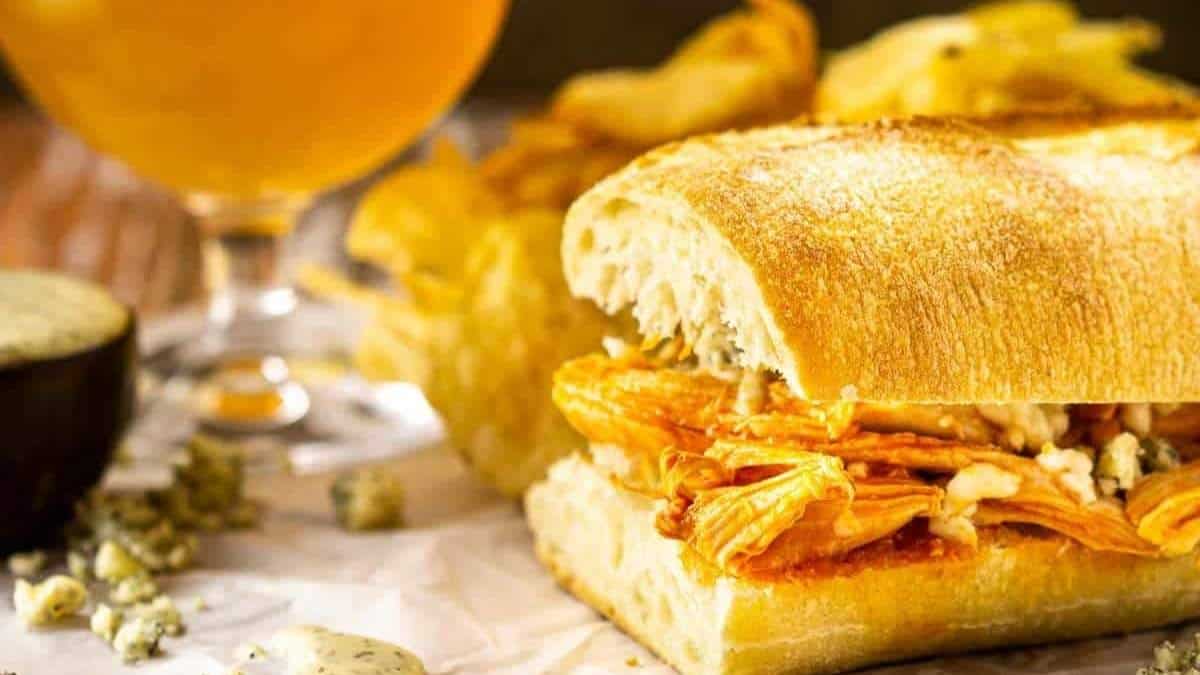 A sandwich with fries and a beer on a table.