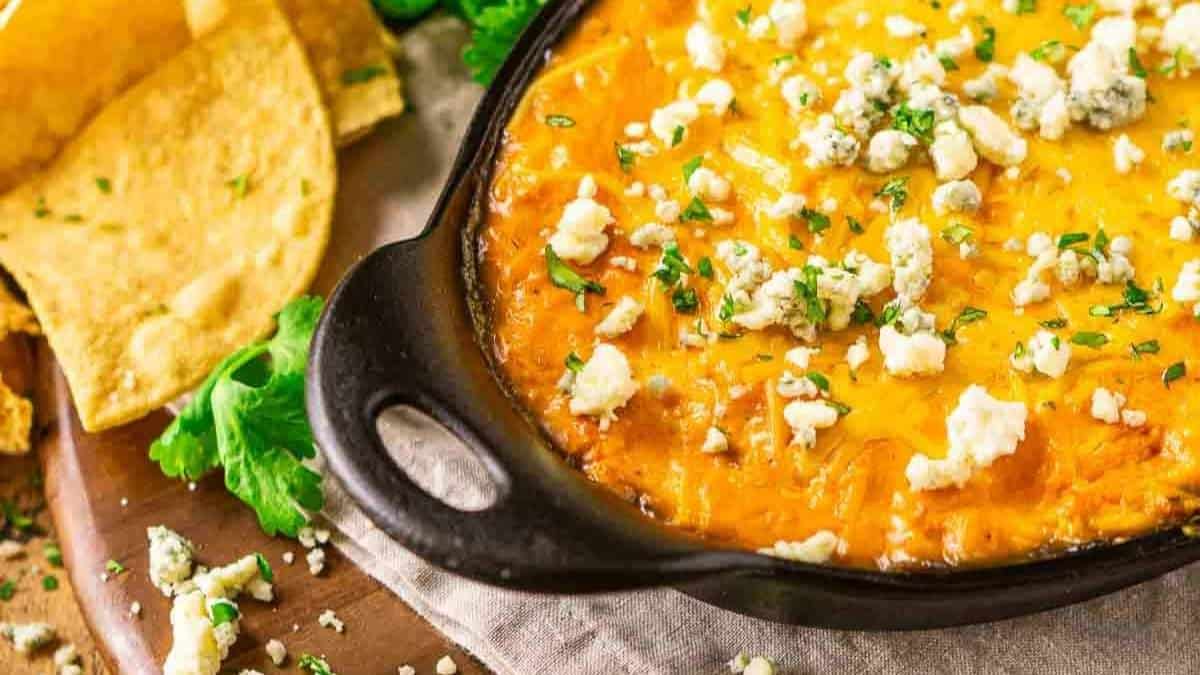 Cheesy corn dip in a skillet with tortilla chips.