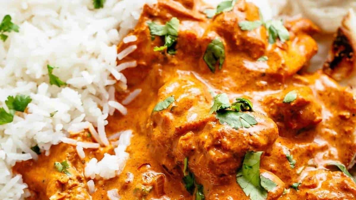 A plate of chicken tikka masala with rice.