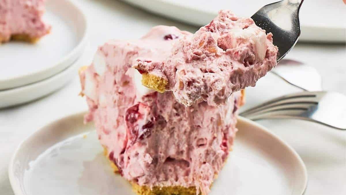 A fork is being used to take a piece of no bake strawberry pie.