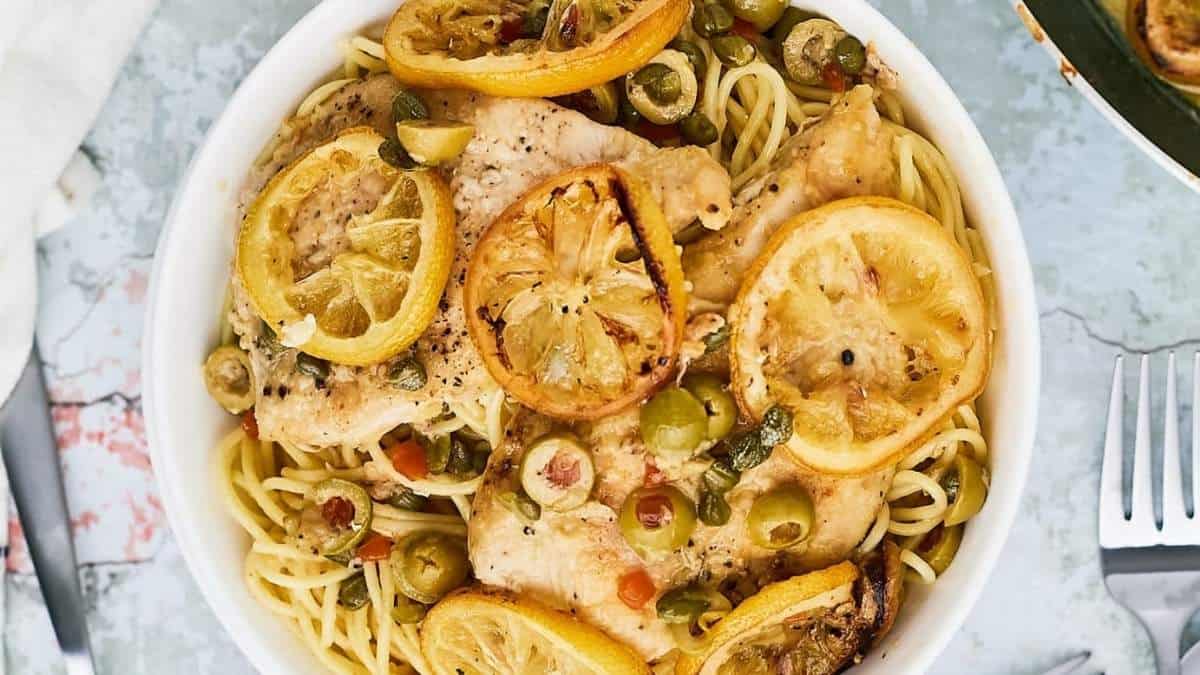 Chicken with lemon and olives in a white bowl.