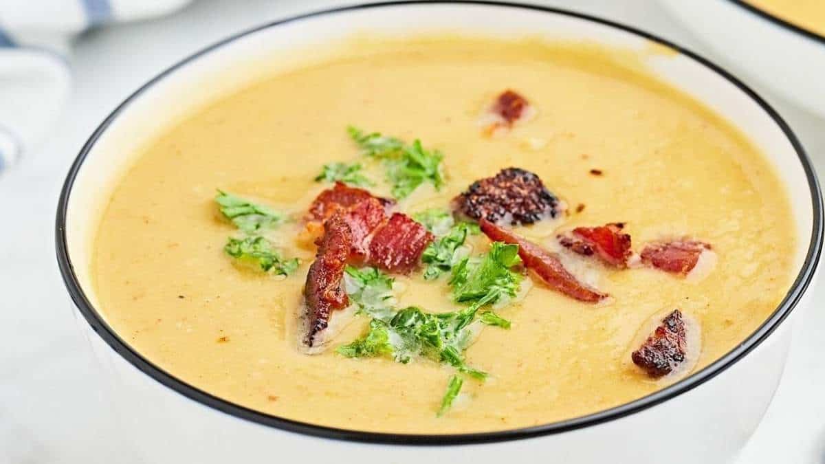 Two bowls of soup with bacon and parsley.