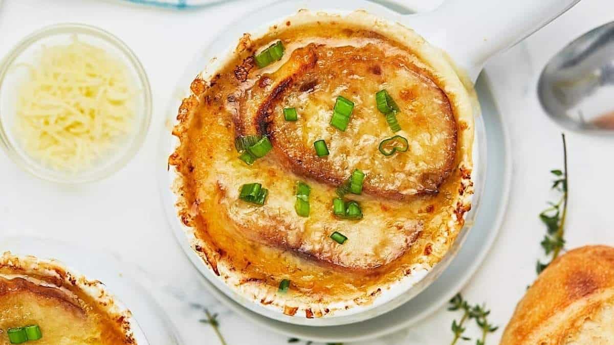 Two bowls of cheesy potato soup, a delicious and comforting soup, served on a white plate.