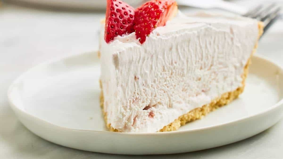 A shared slice of strawberry pie on a round white plate.