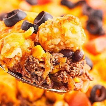 A shared spoonful of Mexican casserole with black beans and black olives, perfect for comfort food recipes.